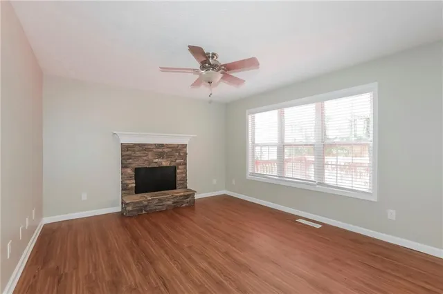 wooden floor fireplace and windows in an empty room