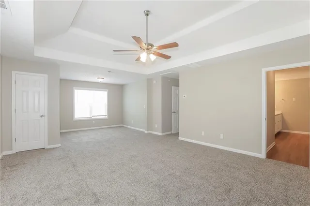 a view of a room with a ceiling fan and a window