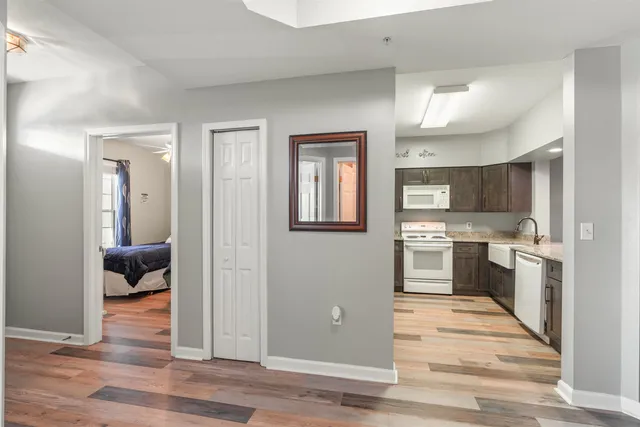 a view of a hallway with wooden floor and a living room