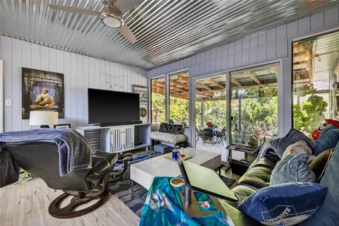 a living room with furniture a flat screen tv and a large window