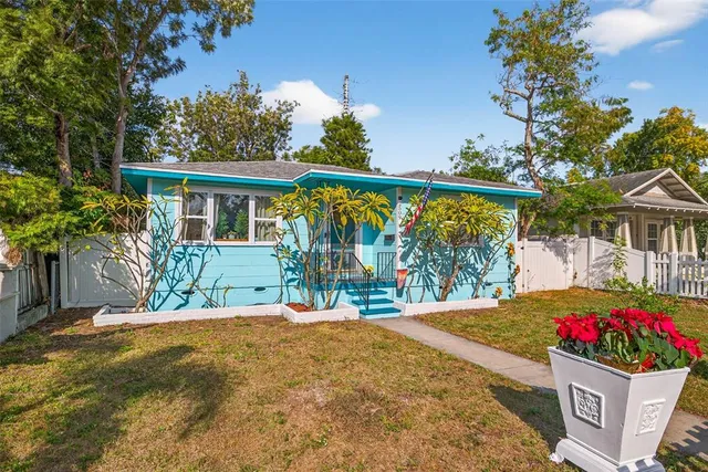 a view of a house with a small yard and a tree
