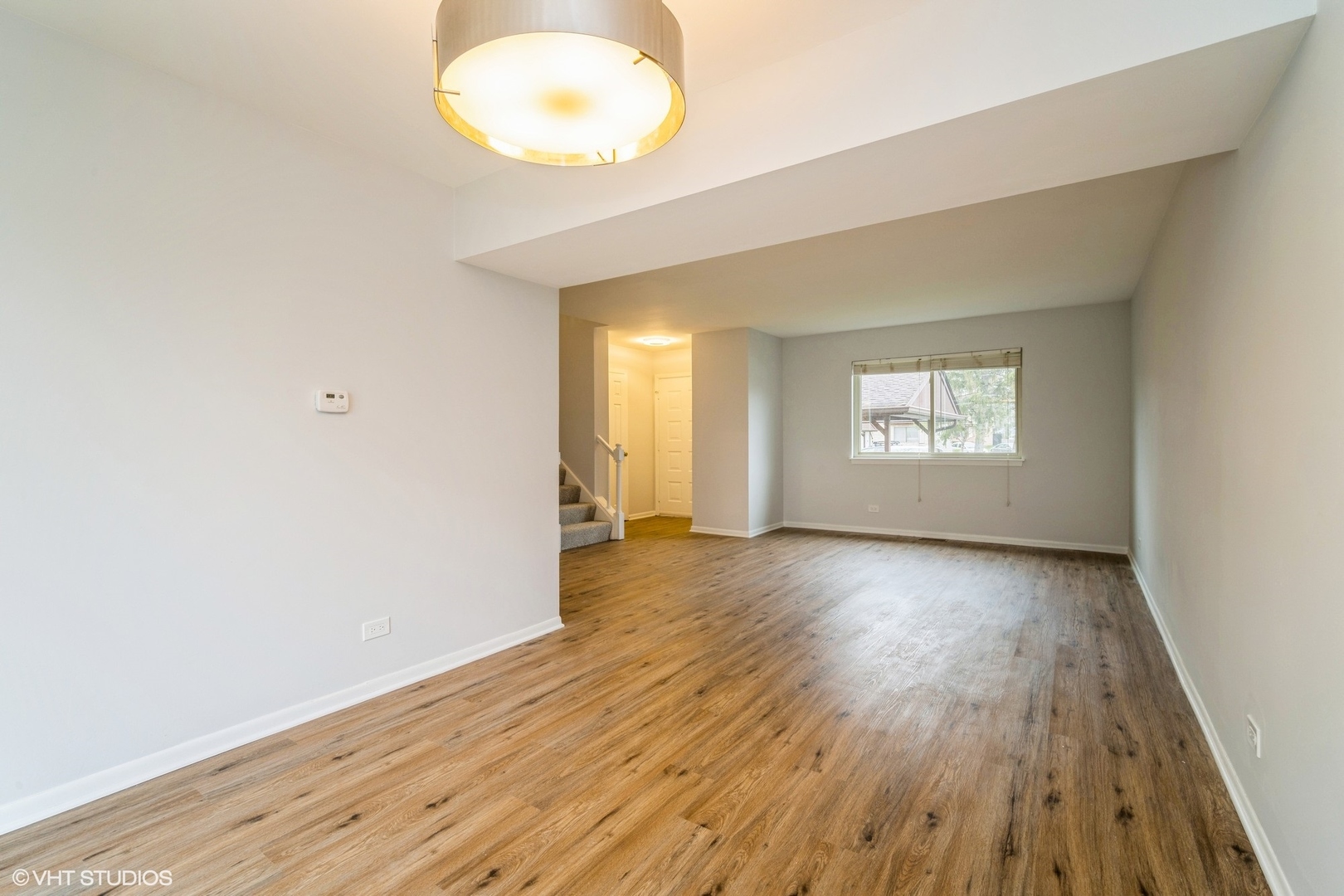 1515 Mohawk Trail Wheeling, IL 60090 - Photo 7 of 22 an empty room with wooden floor and windows