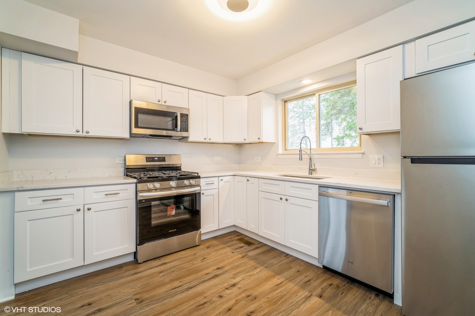 1515 Mohawk Trail Wheeling, IL 60090 - Photo 8 of 22 a kitchen with cabinets stainless steel appliances a sink and a window
