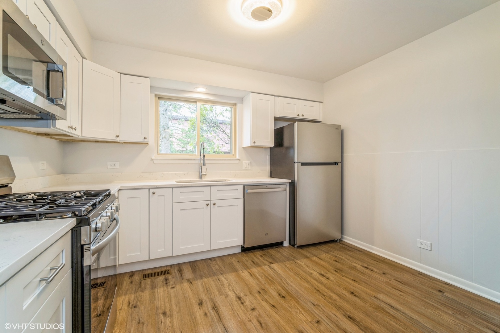 1515 Mohawk Trail Wheeling, IL 60090 - Photo 9 of 22 a kitchen with a sink cabinets stainless steel appliances and a window