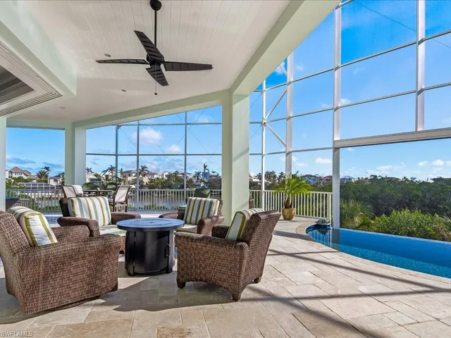 a living room with patio furniture and a floor to ceiling window