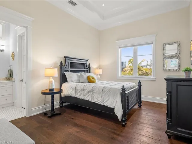 a bedroom with a bed and a lamp on the dresser