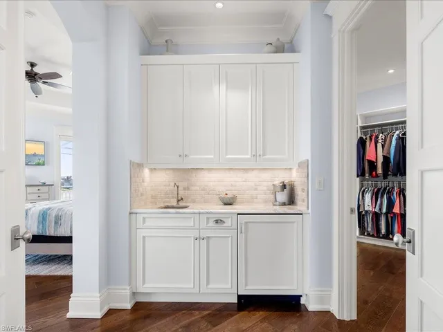 a kitchen with white cabinets and sink