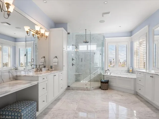 a large bathroom with a double vanity sink a large mirror and a bathtub