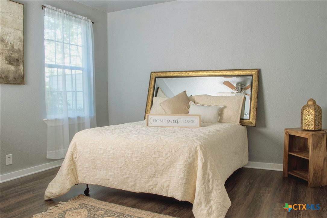 1407 South 7th Street Temple, TX 76504 - Photo 15 of 36 a bedroom with a bed and wooden floor