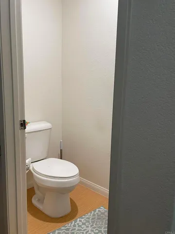 a white toilet sitting next to a white wall