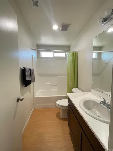 a bathroom with a sink a toilet a tub and shower