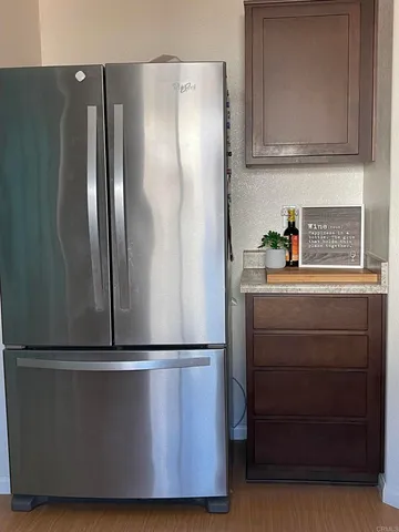 a close view of a refrigerator in kitchen and stainless steel appliances wooden cabinet