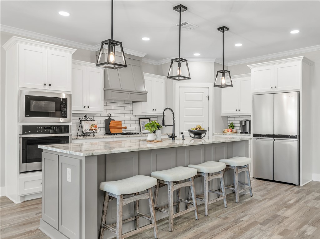 2905 GOLDBERG Drive Bryan, TX 77808 - Photo 8 of 31 a kitchen with stainless steel appliances granite countertop a sink a stove a refrigerator and chairs