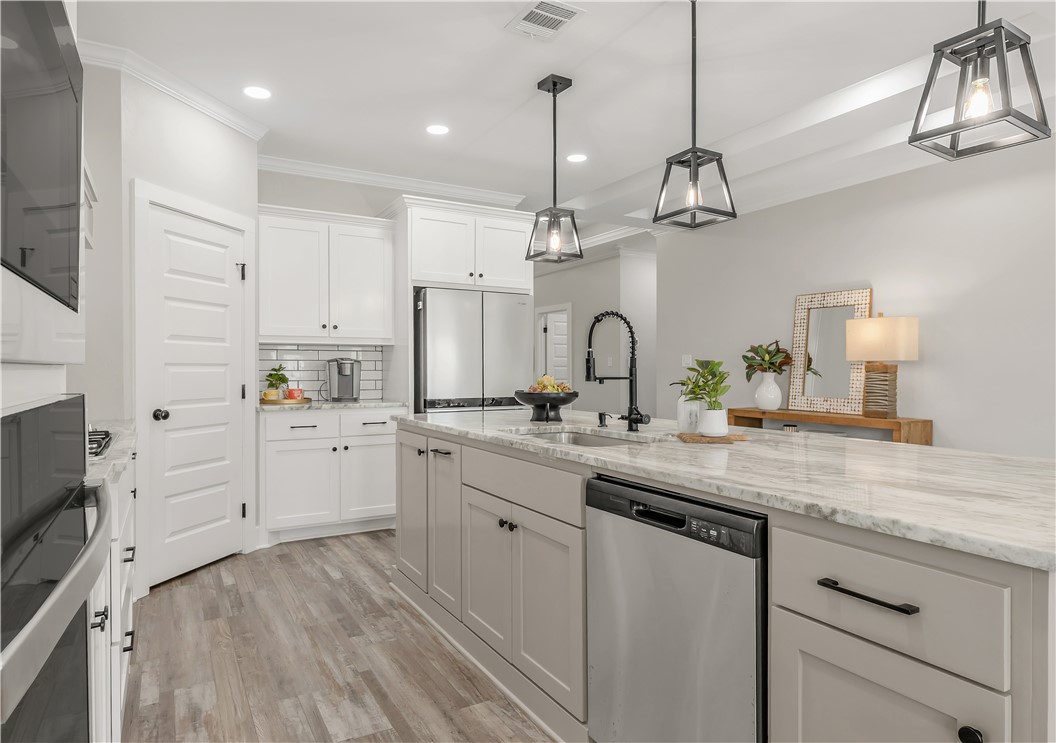 2905 GOLDBERG Drive Bryan, TX 77808 - Photo 9 of 31 a kitchen with white cabinets and chandelier