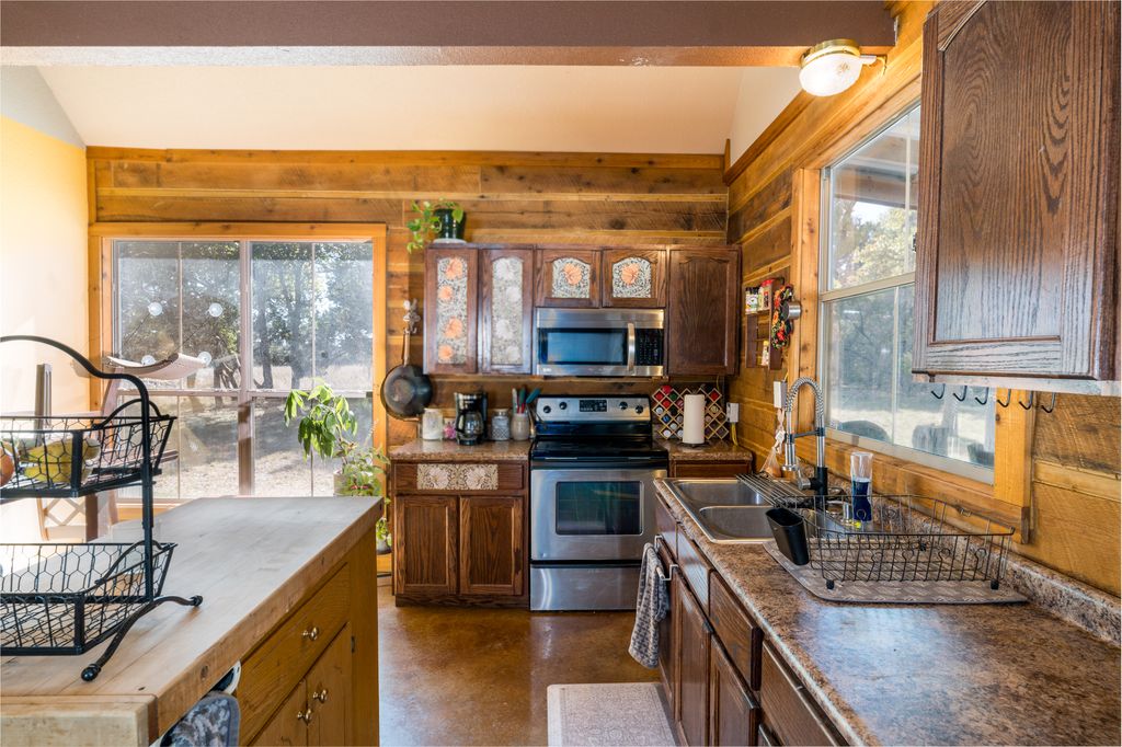 14801 Cedar Valley Road Salado, TX 76571 - Photo 8 of 16 a kitchen with stainless steel appliances granite countertop a stove a sink and a microwave