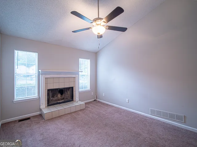 an empty room with fireplace and fan