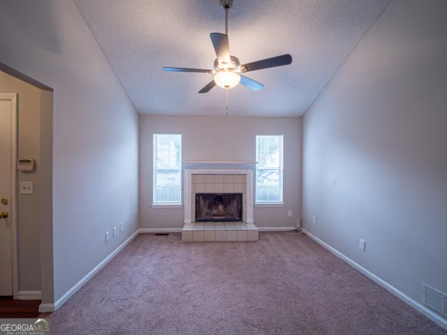 a view of an empty room with a fireplace and a window