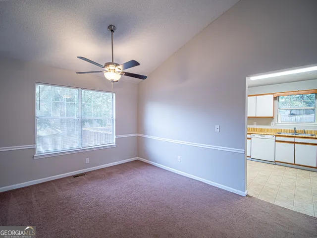 an empty room with a window and a kitchen