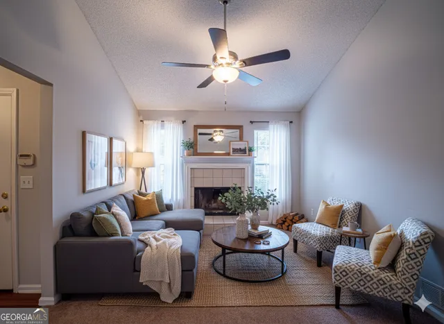 a living room with furniture a fireplace and a chandelier