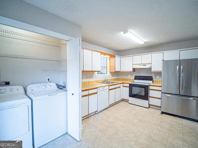 a kitchen with a refrigerator sink and cabinets