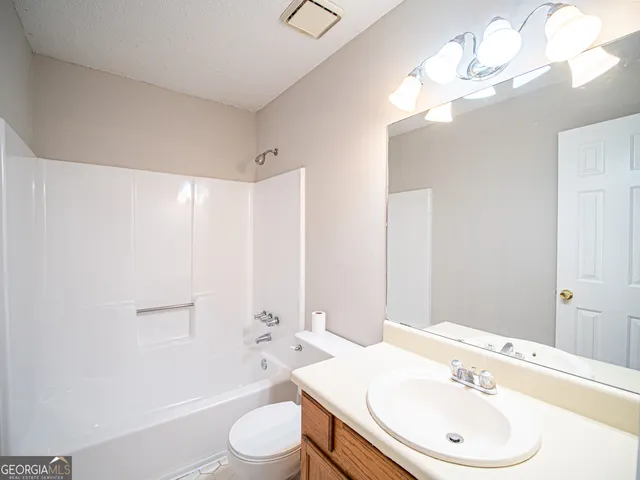 a bathroom with a toilet a sink a mirror and bathtub