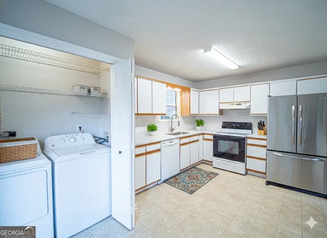 a kitchen with a refrigerator sink and cabinets
