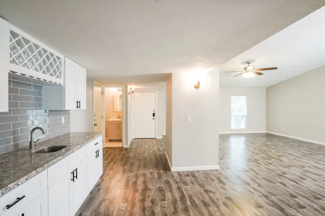 a view of an empty room with a window and wooden floor