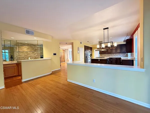a view of a kitchen with wooden floor and a window