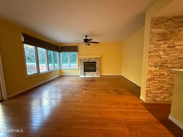 a view of a livingroom with wooden floor a fireplace and window