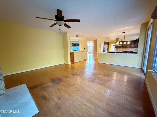 a view of a living room and kitchen with wooden floor