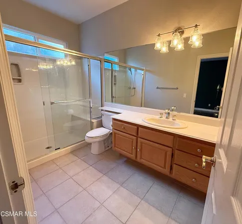 a bathroom with a double vanity sink mirror and toilet