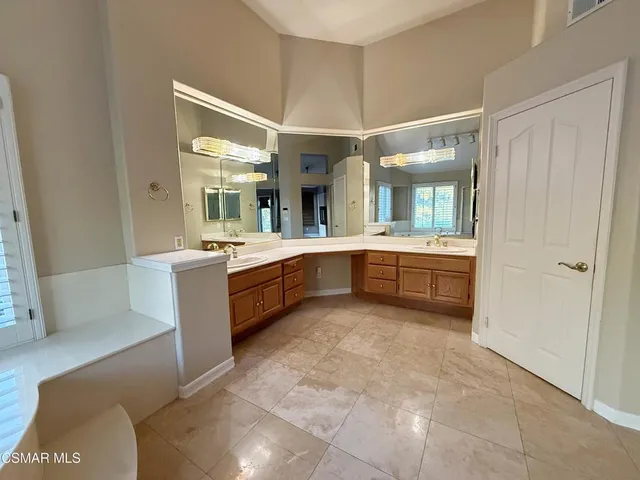 a bathroom with a tub sink shower and mirror