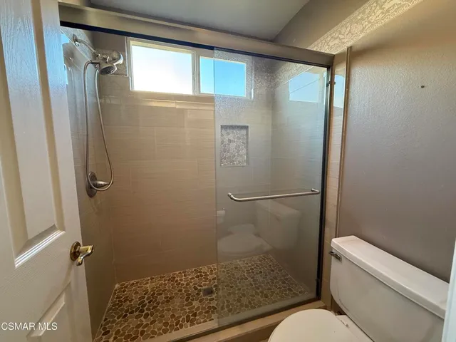 a bathroom with a granite countertop bathtub shower and toilet