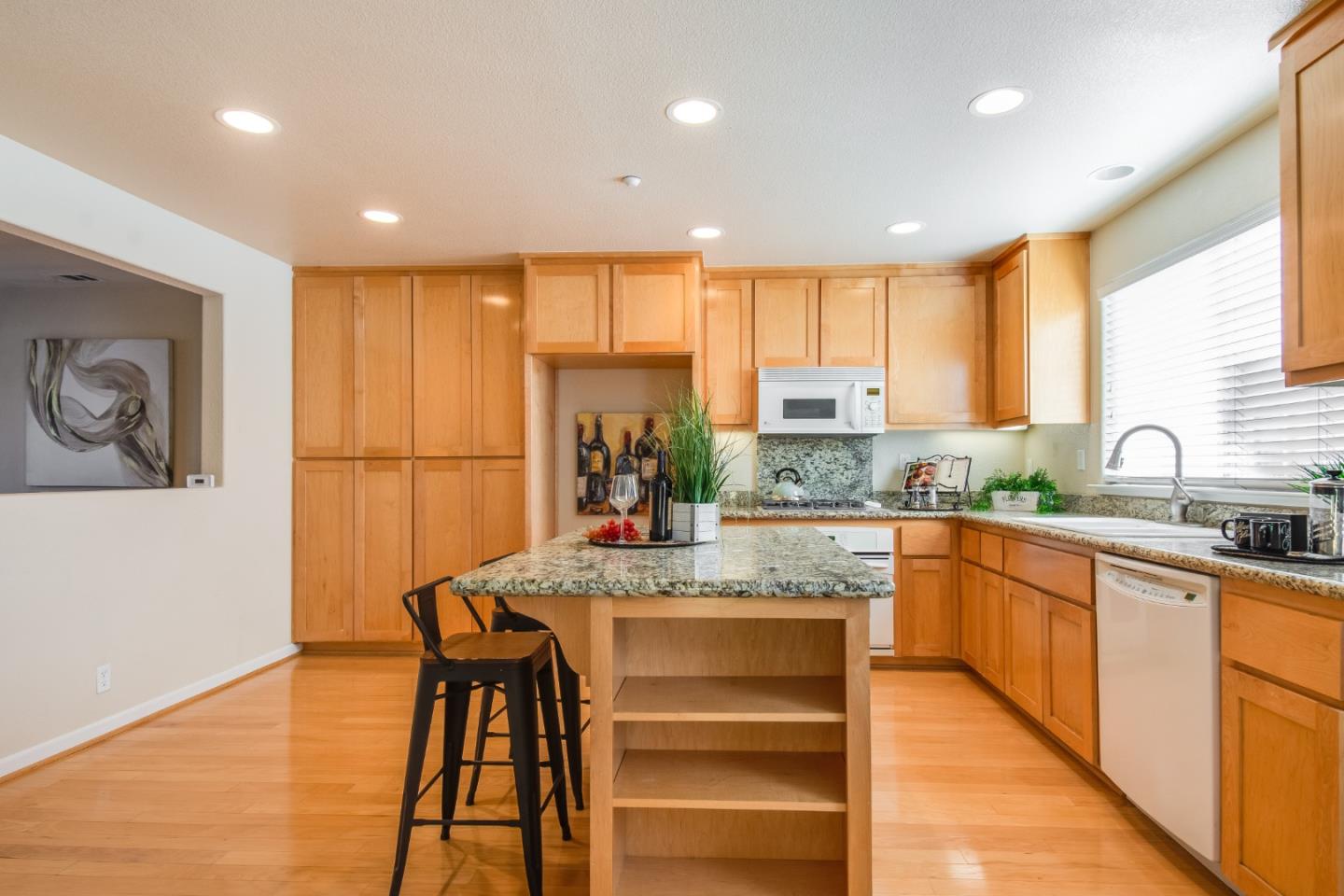 255 Vista Roma Way San Jose, CA 95136 - Photo 12 of 29 a large kitchen with stainless steel appliances granite countertop a stove a sink dishwasher and a refrigerator with wooden floor