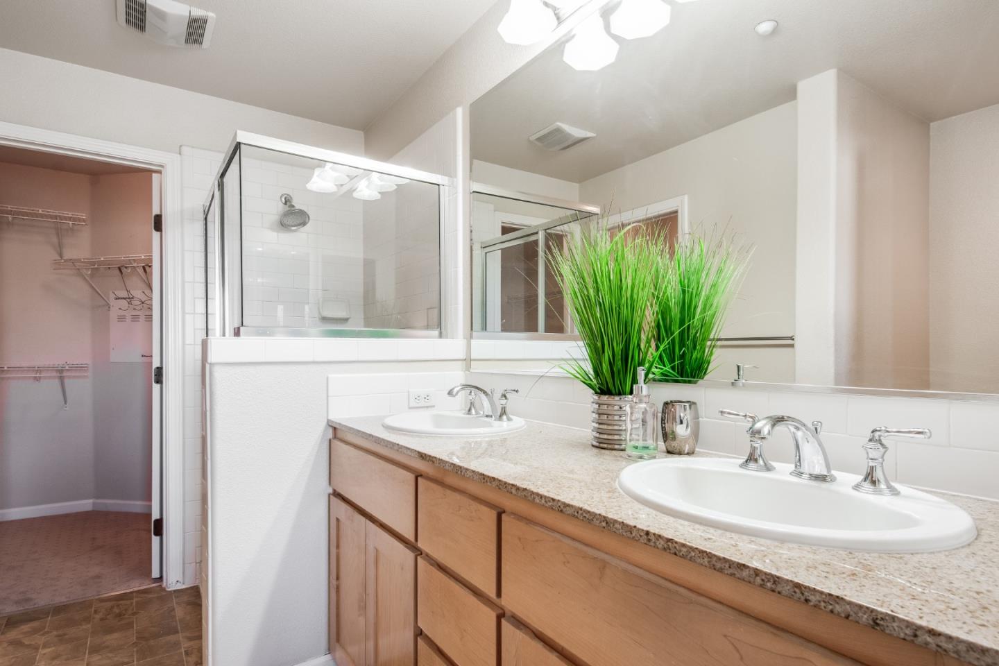 255 Vista Roma Way San Jose, CA 95136 - Photo 17 of 29 a bathroom with a double vanity sink and a mirror