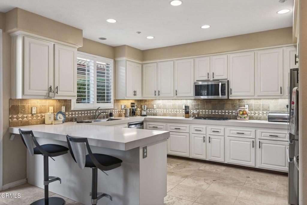 4337 Admiral Way Oxnard, CA 93035 - Photo 15 of 67 a kitchen with stainless steel appliances granite countertop a table chairs sink and cabinets