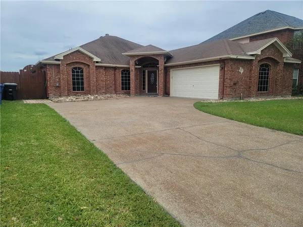a front view of a house with a garden and yard