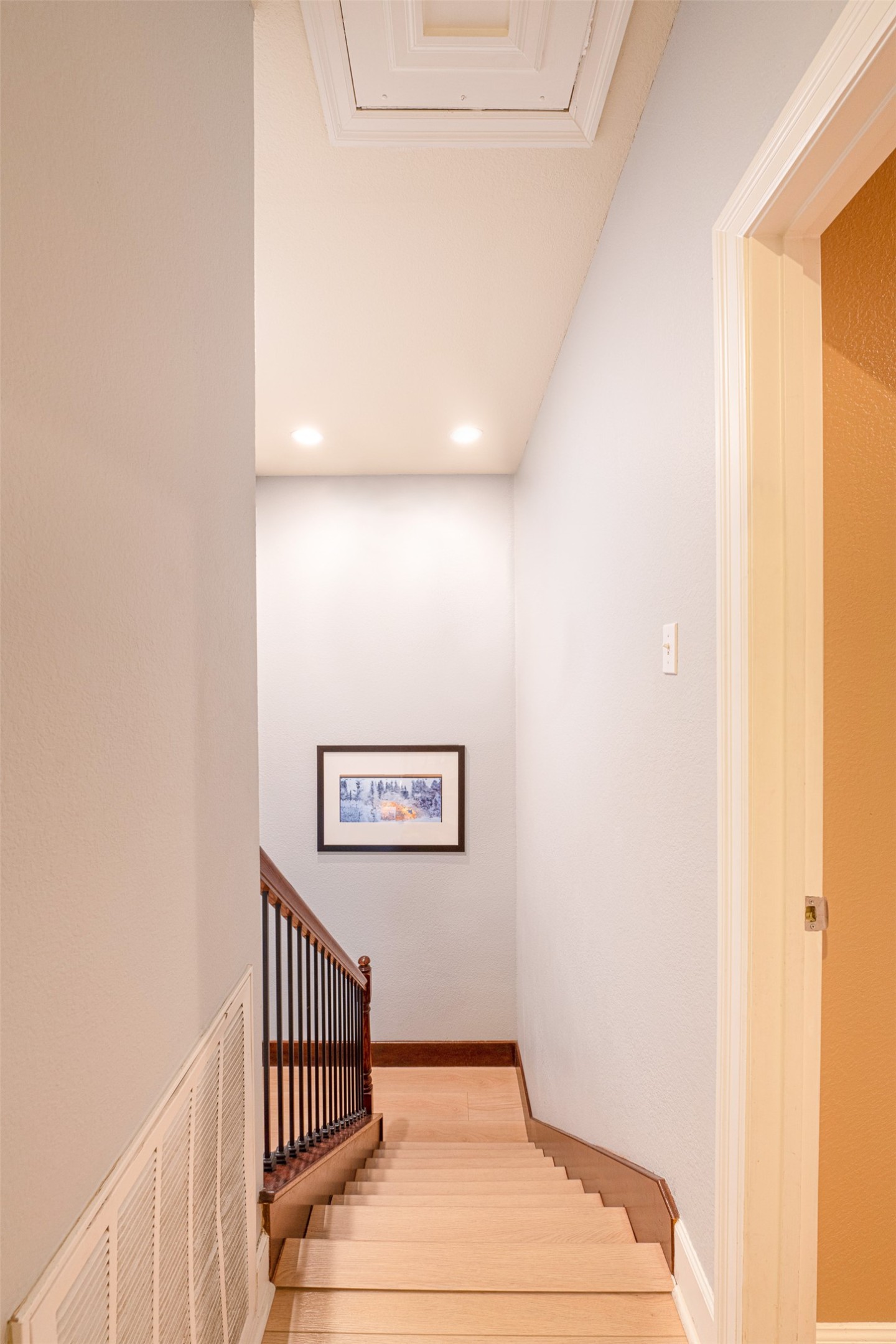2302 East 9th Street Austin, TX 78702 - Photo 20 of 31 Ascend to comfort on natural wood stairs, featuring recessed lighting and a sleek railing.
