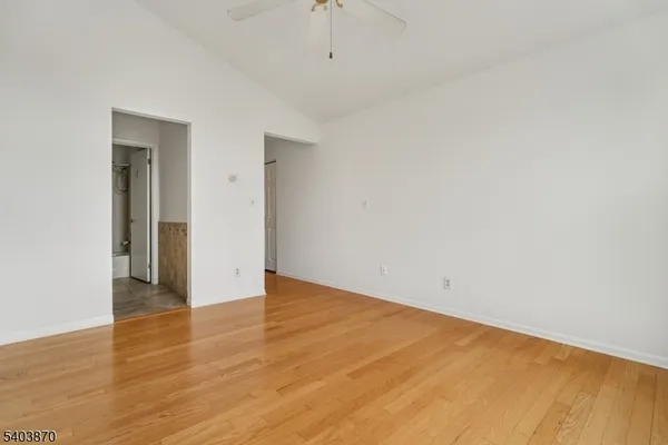 a view of an empty room with wooden floor