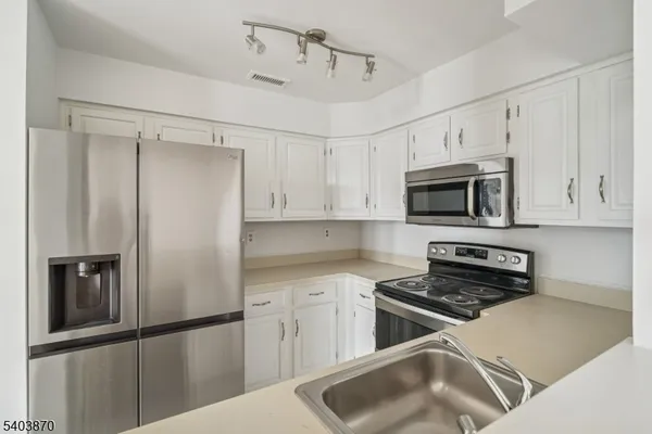a kitchen with white cabinets and stainless steel appliances