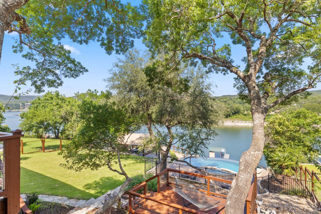 10800 Beach Road Leander, TX 78641 - Photo 29 of 39 A tranquil lakeside retreat features a refreshing pool, expansive yard, and private deck for ultimate relaxation.