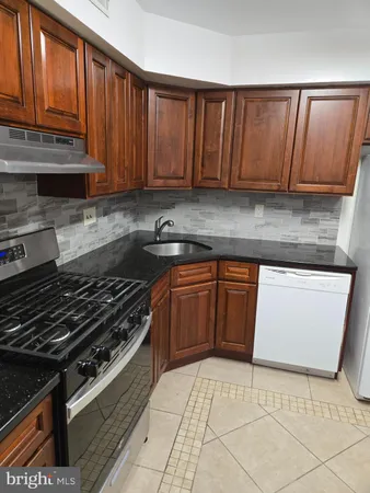 a kitchen with wooden cabinets and a stove top oven