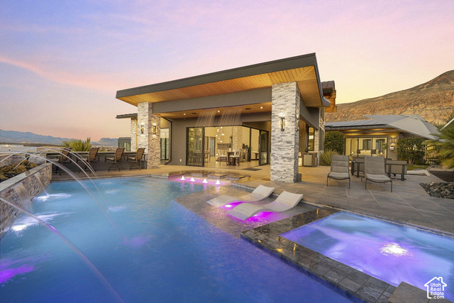 3652 South Cypress Road Hurricane, UT 84737 - Photo 80 of 81 Modern exterior architecture featuring a flat roofline, stacked stone accents, and expansive glass doors