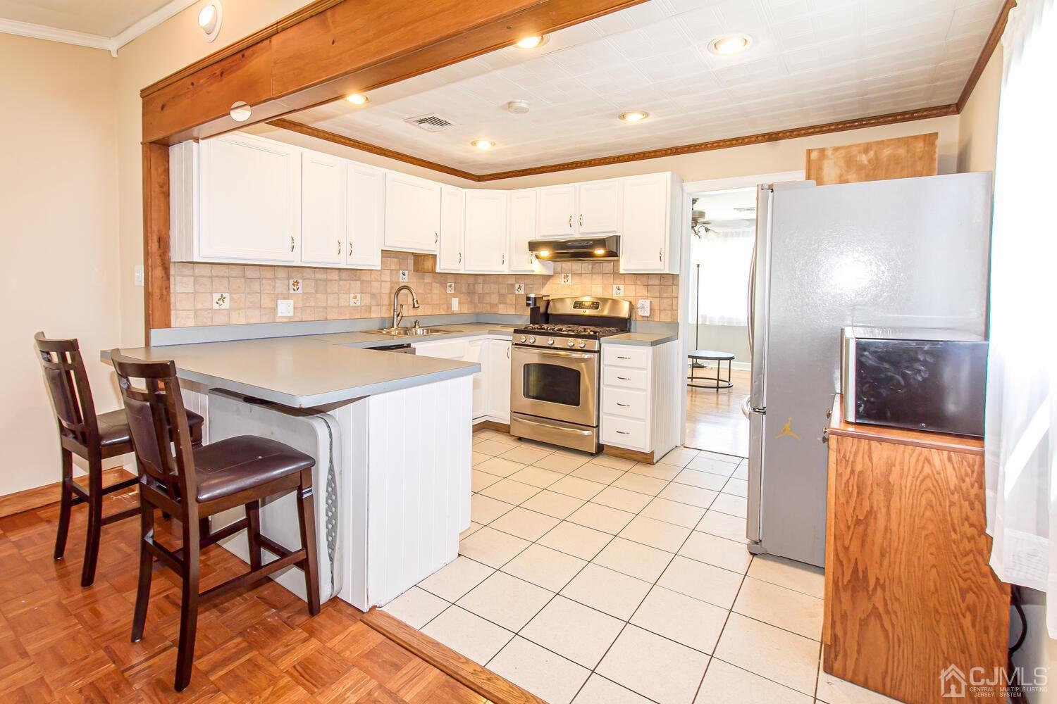 29 Ashley Road Edison, NJ 08817 - Photo 14 of 30 a kitchen with stainless steel appliances a stove a sink refrigerator and a dining table