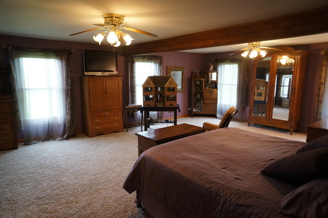 8101 West Bruns Road Monee, IL 60449 - Photo 14 of 25 a bedroom with a bed and a chandelier