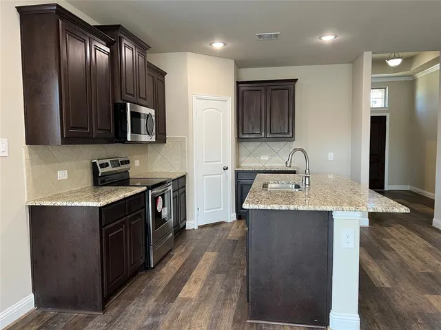 a kitchen with a stove sink and cabinets