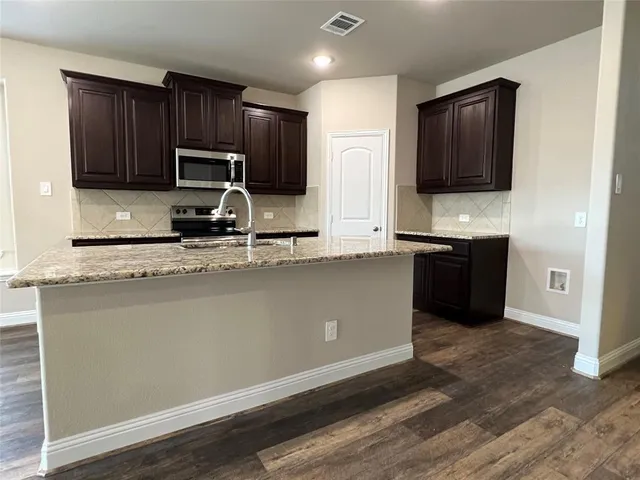 a kitchen with wooden cabinets and a sink