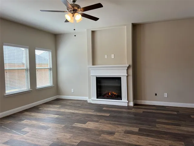 a view of an empty room with window and fireplace