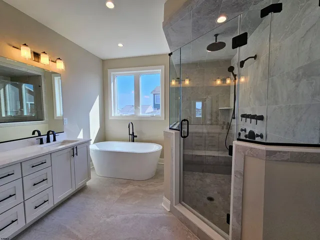 a spacious bathroom with a double vanity sink a large mirror and a bathtub