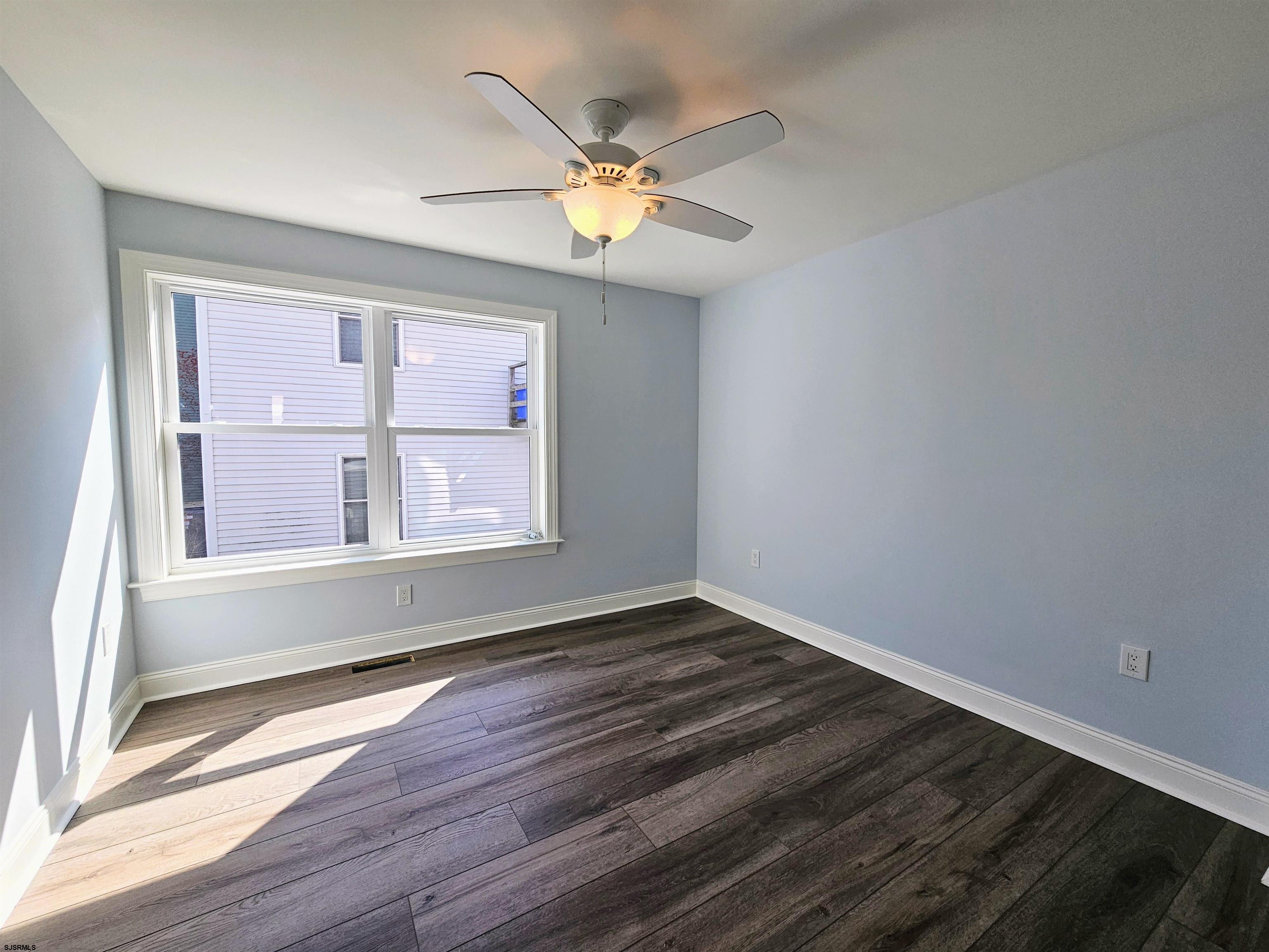222 8th Street South Brigantine, NJ 08203 - Photo 4 of 27 a view of an empty room with wooden floor and a window